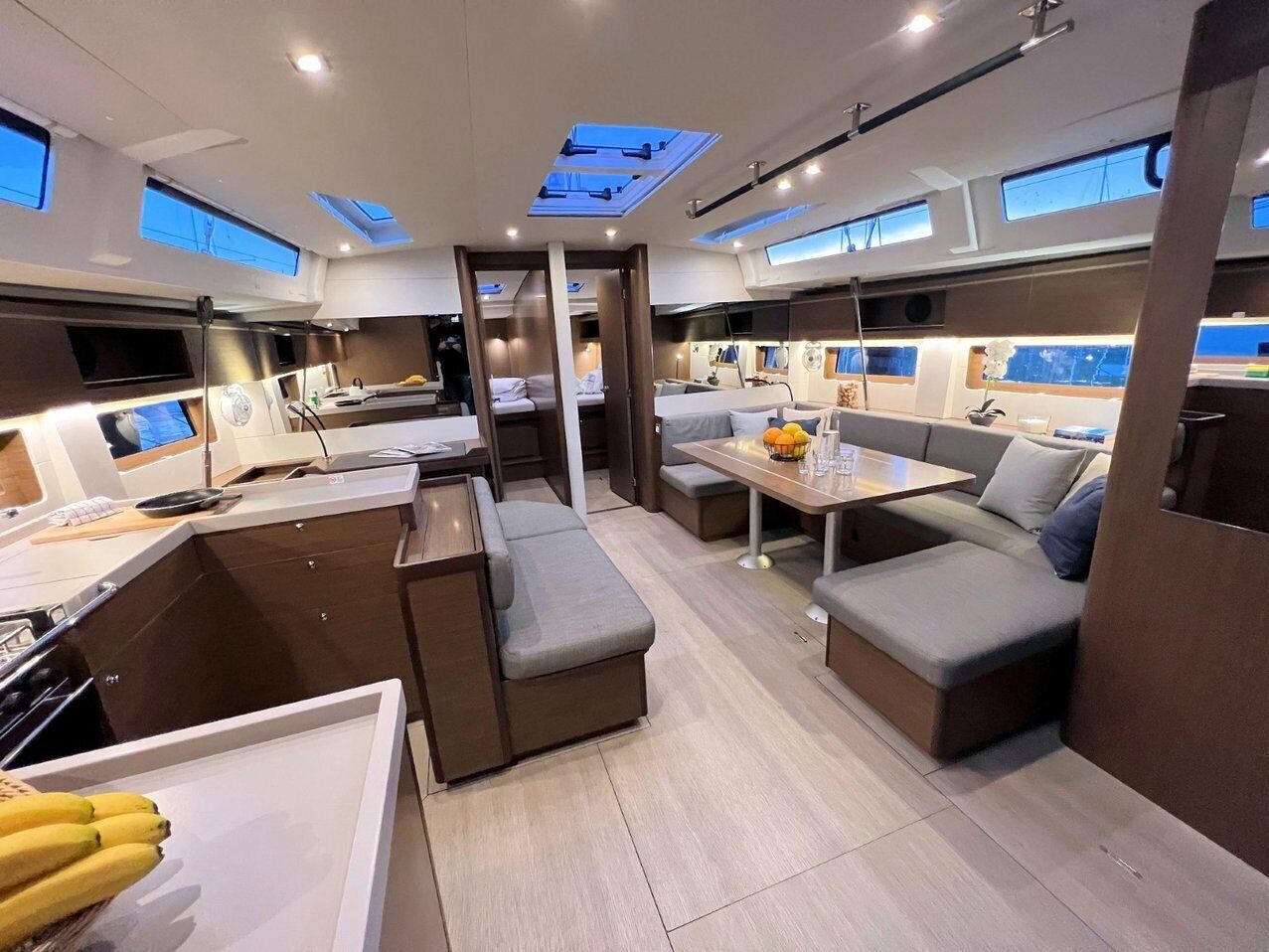 A modern interior with a central dining area, seating arrangements, and skylights.