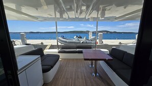 A boat deck with seating, a table, and a view of the water. - Sun-kissed Sailing Adventure in Split-Dalmatia, Croatia (Seget Donji)