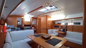 A compact, well-lit interior with a dining area, seating, and a small kitchenette. - Sun-Kissed Sailing Adventure in the Ionian Islands, Lefkada (Lefkada)