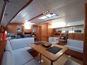 A compact, well-lit interior with a dining area, seating, and a small kitchenette. - Sun-Kissed Sailing Adventure in the Ionian Islands, Lefkada (Lefkada)