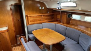 A compact galley with a wooden table, cushioned seating, and a small galley window. - Sun-Kissed Sailing Adventure in Split-Dalmacia, Croatia (Omiš)