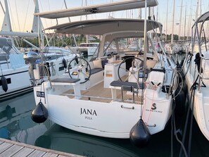 A marina with a white yacht named 'JANA PULA' docked, featuring a cabin, steering wheel, and a winch. - Sun-Kissed Sailing Adventure in Istria, Croatia (Pula)