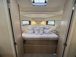 A compact, well-lit bedroom with a skylight, neatly made bed, and a small bedside table. - Sun-Kissed Sailing Adventure in Istria, Croatia (Pula)