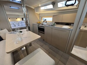 A compact kitchen with a dining area, a small oven, and a sink. - Sun-Kissed Sailing Adventure in Istria, Croatia (Pula)