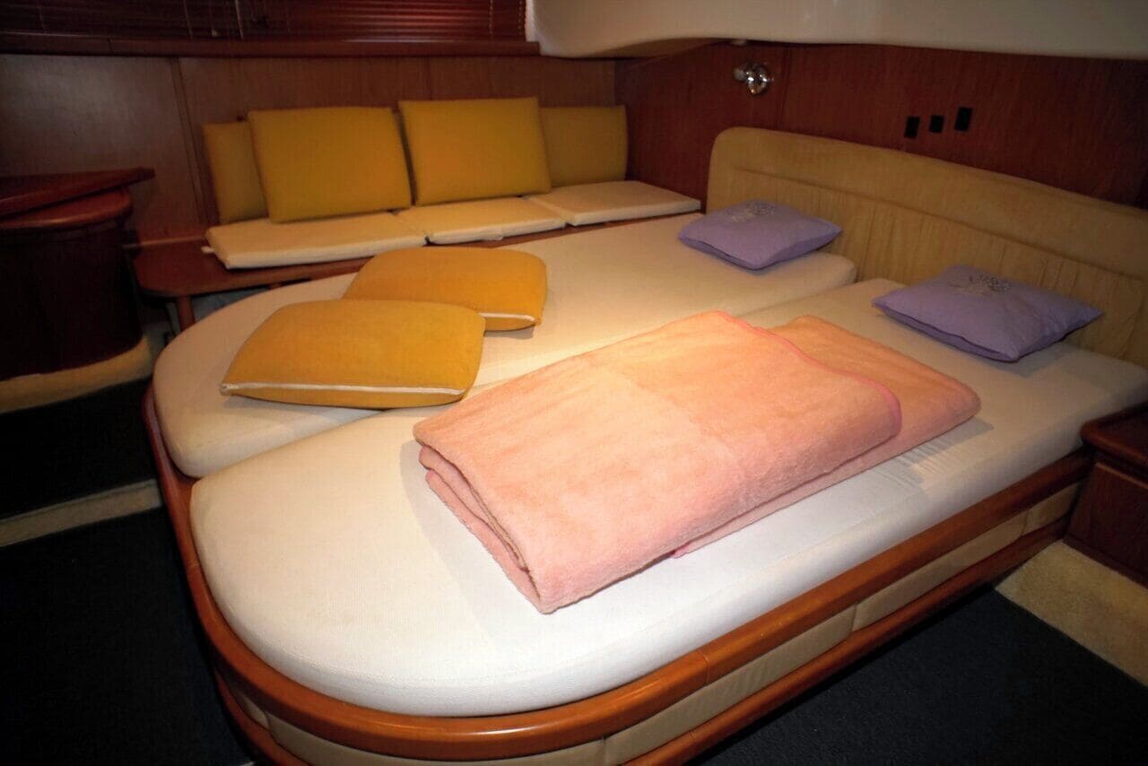 A compact bed with a wooden frame, a headboard, and a bedside table.