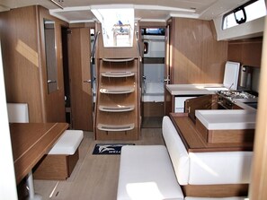 A compact interior with a kitchenette, a dining area, and a seating space. - Sun-Kissed Sailing Adventure in Zadar, Croatia (Bibinje)