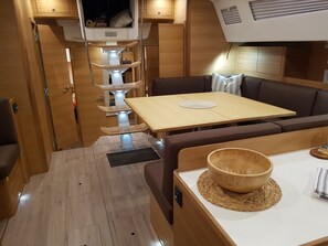 Ein kompaktes Wohnmobil-Interieur mit Essbereich, einer Sitzecke und einer kleinen Küchenzeile.