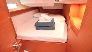 Ein kleines, gemütliches Zimmer mit Bett, Tisch und Fenster.