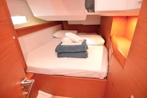 Ein kleines, gemütliches Zimmer mit Bett, Tisch und Fenster.