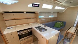 Una cocina compacta con pileta, estufa y alacenas.