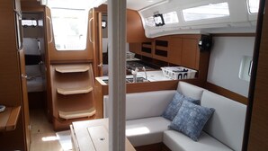A compact interior with a kitchenette, seating area, and storage cabinets.