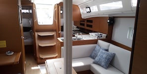 A compact interior with a kitchenette, seating area, and storage cabinets.