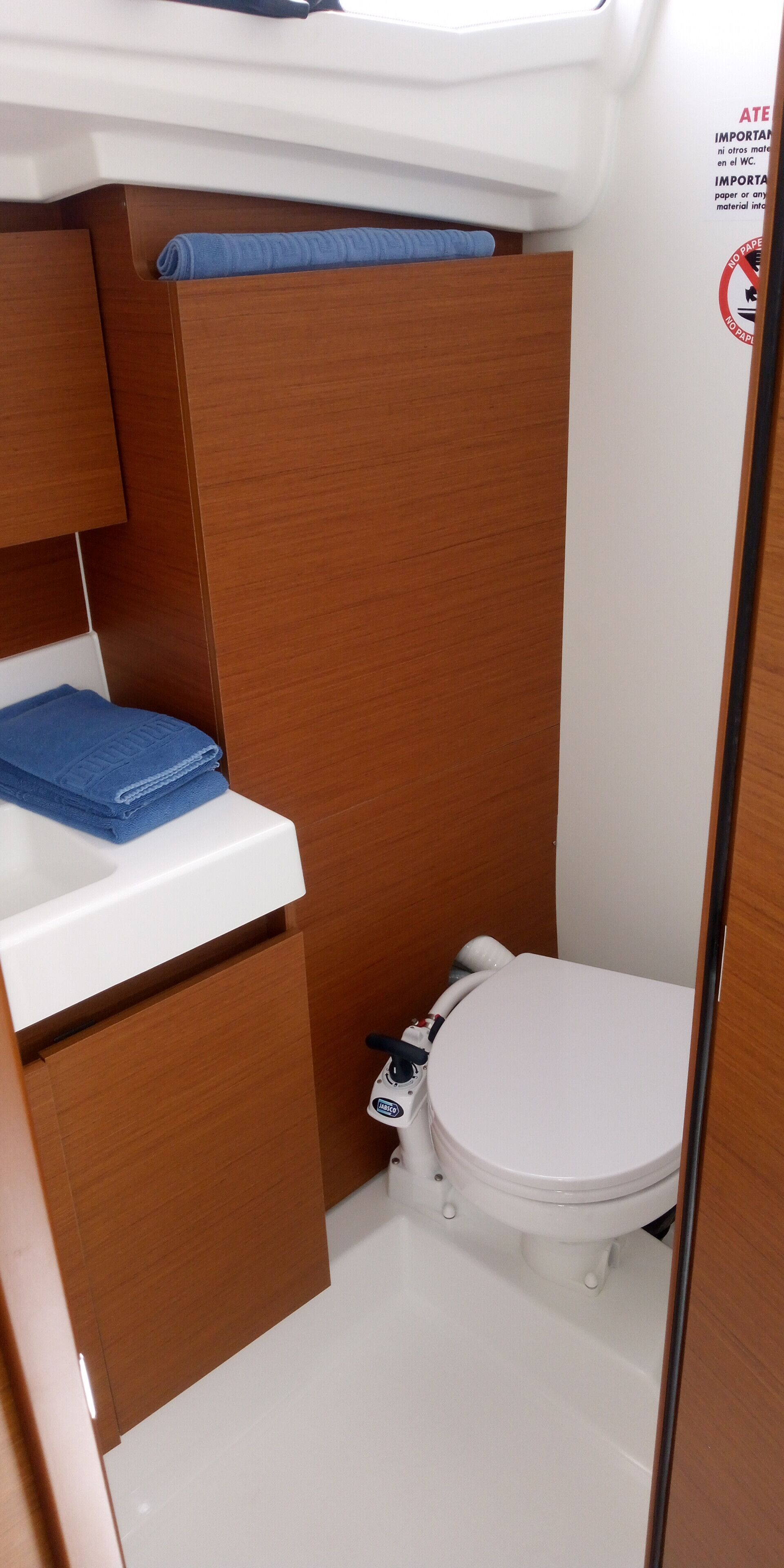 Une petite salle de bain comprenant des toilettes, un lavabo et un petit meuble de rangement.