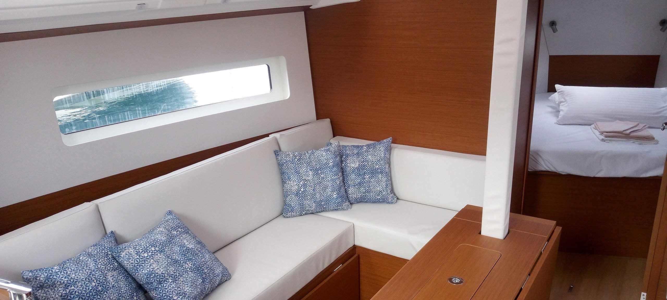 A compact interior with a sofa set, pillows, a small table, and a bed.