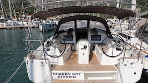 Ein Bootsdeck mit einem 'SHAKEN NOT STIRRED' Schild, einem Steuer und einer Bedieneinheit.