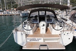 Ein Bootsdeck mit einem 'SHAKEN NOT STIRRED' Schild, einem Steuer und einer Bedieneinheit.