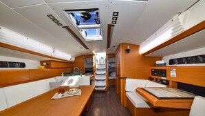 Interior compacto e bem iluminado, com área de jantar, assentos e painel de controle.