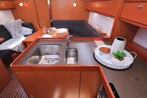 A compact kitchenette with a sink, a small dining area, and a seating space. - Sun-Kissed Sailing Adventure in Zadar, Croatia (Biograd na moru)