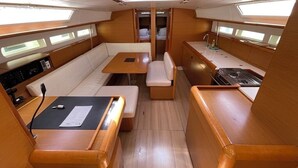 A compact, well-lit interior with a dining area, seating, and a kitchenette. - Sun-Kissed Sailing Adventure in Zadar, Croatia (Bibinje)