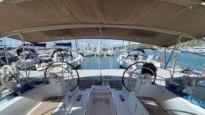 A marina with multiple boats docked, a covered deck area, and a view of the water. - Sun-Kissed Sailing Adventure in Zadar, Croatia (Bibinje)