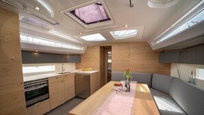 Una cocina compacta con una isla central, horno empotrado y comedor con banco.