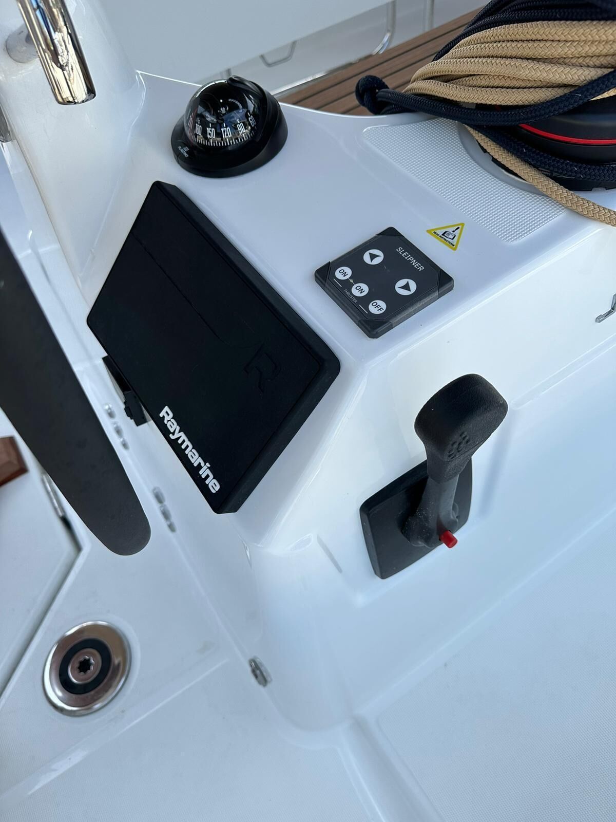 A control panel with a Raymarine device, a speedometer, a sleep mode switch, and a throttle lever.