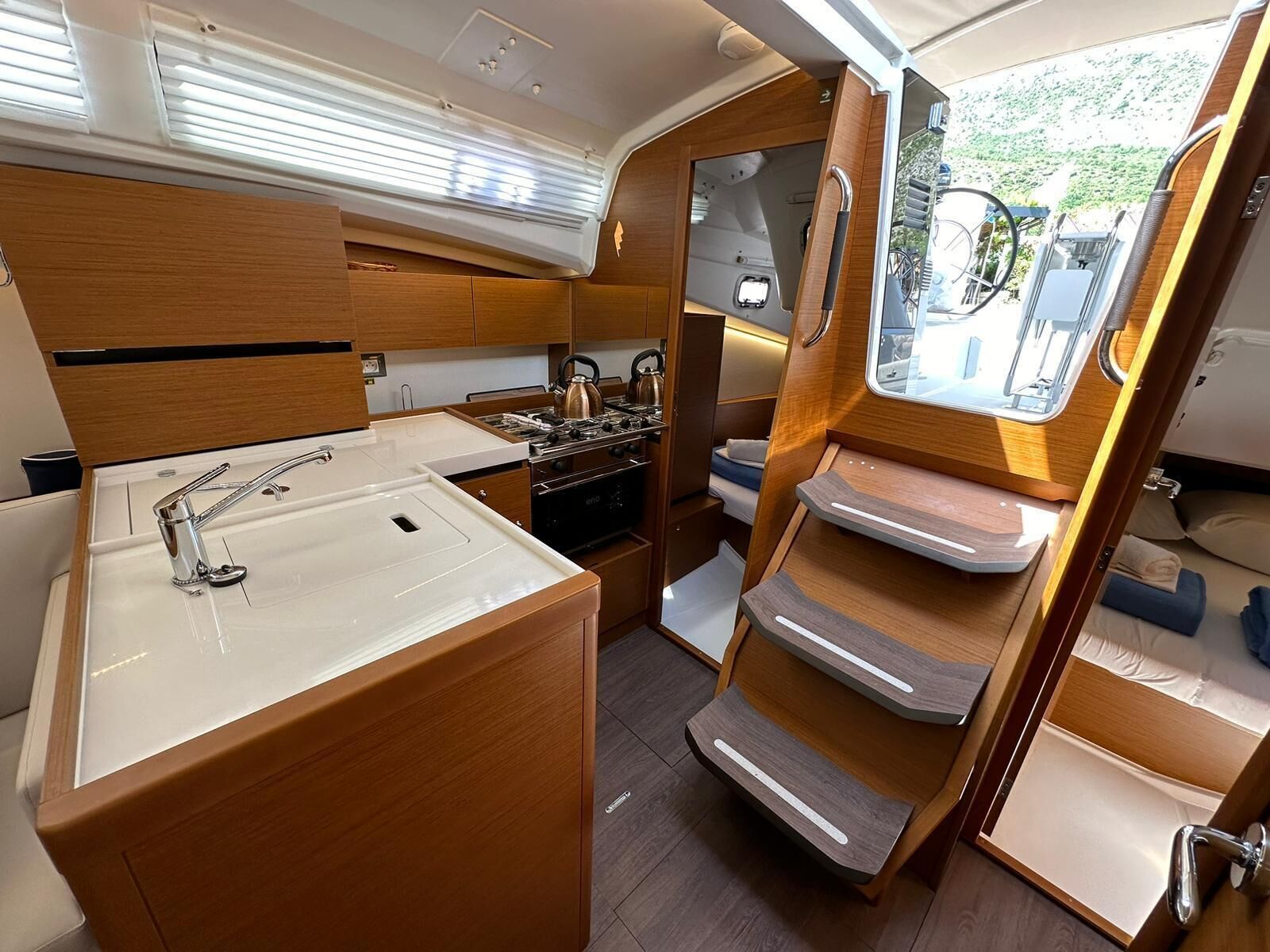 A compact galley with a sink, stove, and storage cabinets.