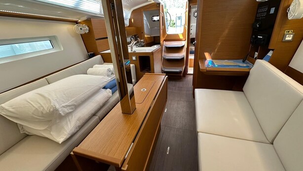 A compact interior with a bed, a small table, a seating area, and a kitchenette. - Dubrovnik Delight: A Sun-Kissed Sailing Experience (Komolac)