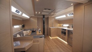 A compact kitchen with modern appliances, a dining area with a small table, and a sofa. - Sun-kissed Sailing Adventure in Split-Dalmatia, Croatia (Seget Donji)