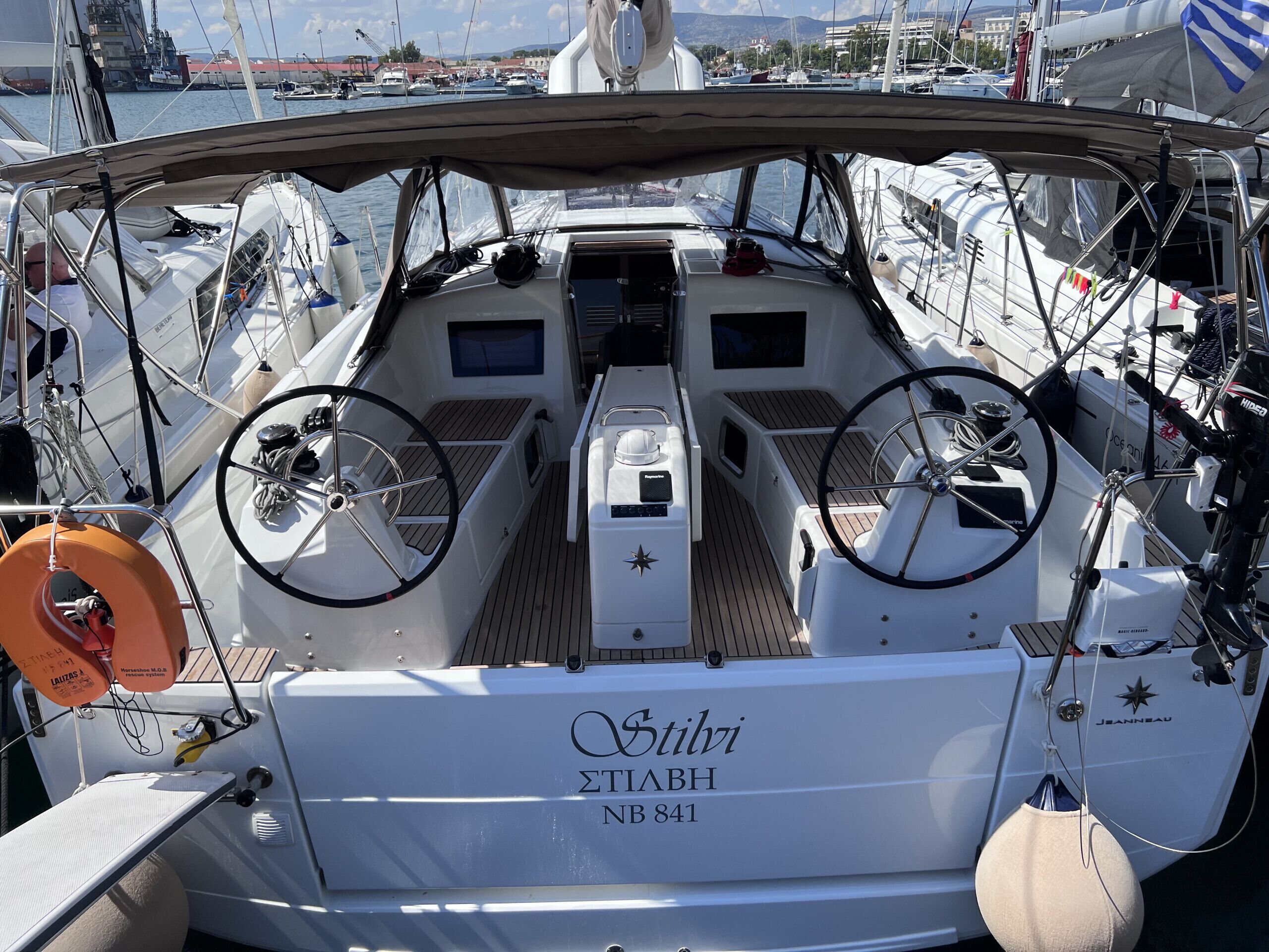 Le pont d’un bateau, avec des roues de direction, une console de pilotage et un gilet de sauvetage.