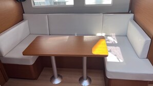 Een gezellig zitgedeelte met een tafel, zachte bankjes en een kleine ventilator.