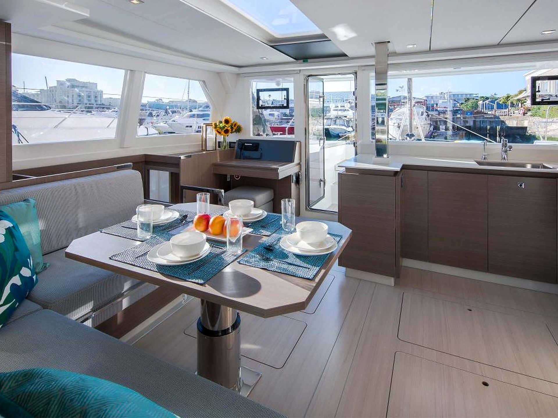 A yacht interior with a dining area, a seating area, and a kitchen.