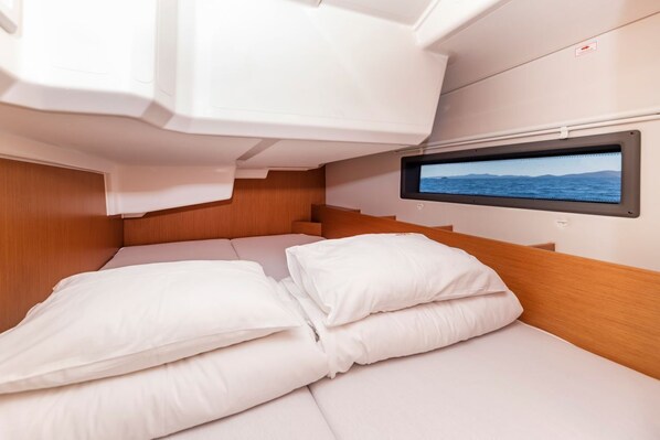 A cabin with a bed, a television screen, and a window with a view of the sea. - Sun-Kissed Sailing Adventure in Zadar, Croatia (Zadar)