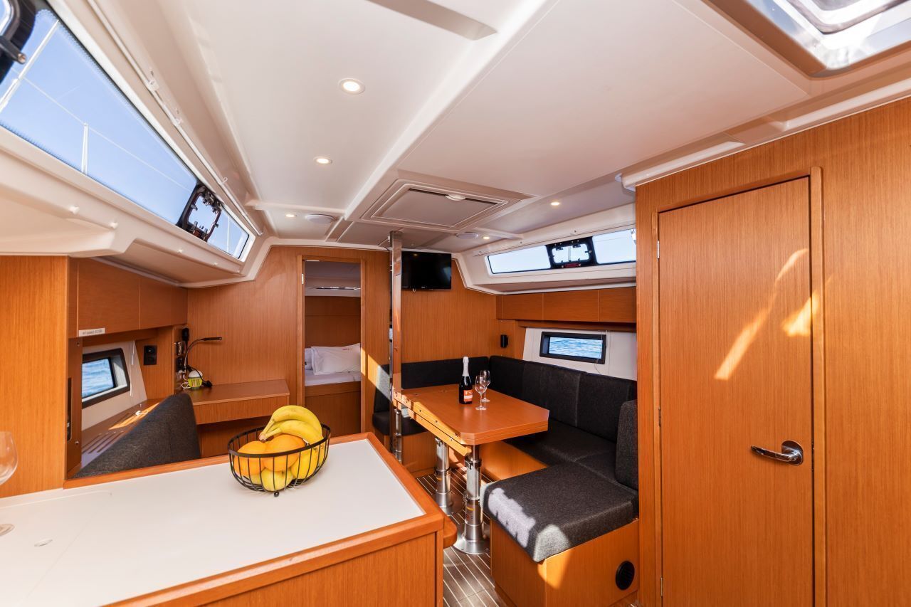A compact interior with a dining area, seating, and a television.