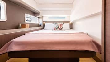 A compact, well-lit room with a bed, bedside tables, and a window.