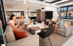 Un intérieur moderne comprenant un coin repas, des canapés et une grande fenêtre donnant sur un paysage.