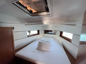 A compact, well-lit cabin with a single bed, a small table, and a window providing natural light. - Sun-Kissed Sailing Adventure in Zadar, Croatia (Bibinje)