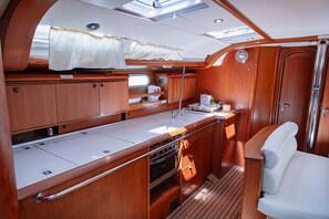 A compact galley with a sink, oven, and storage cabinets. - Sun-kissed Sailing Adventure in Split-Dalmatia, Croatia (Seget Donji)