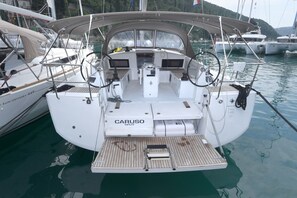 A sailboat docked at a marina with a cabin labeled 'CARUSO SPLIT.' - Dubrovnik Delight: A Sun-Kissed Sailing Experience (Komolac)