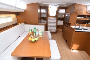 Cocina compacta con comedor, lavamanos y un refrigerador pequeño.