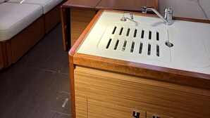 Un intérieur compact comprenant un canapé, une petite table, un évier et une fenêtre.