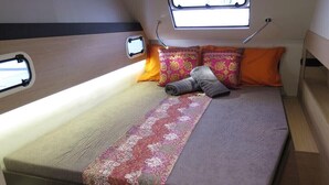 Un lit avec une tête de lit, des oreillers et une couverture.
