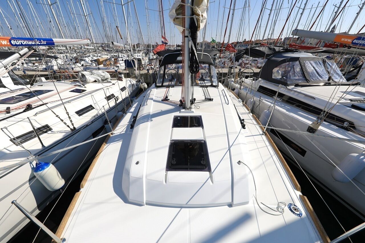 A marina with multiple sailboats docked, a clear sky, and a visible sign with 'euronaut.ch' on the left.