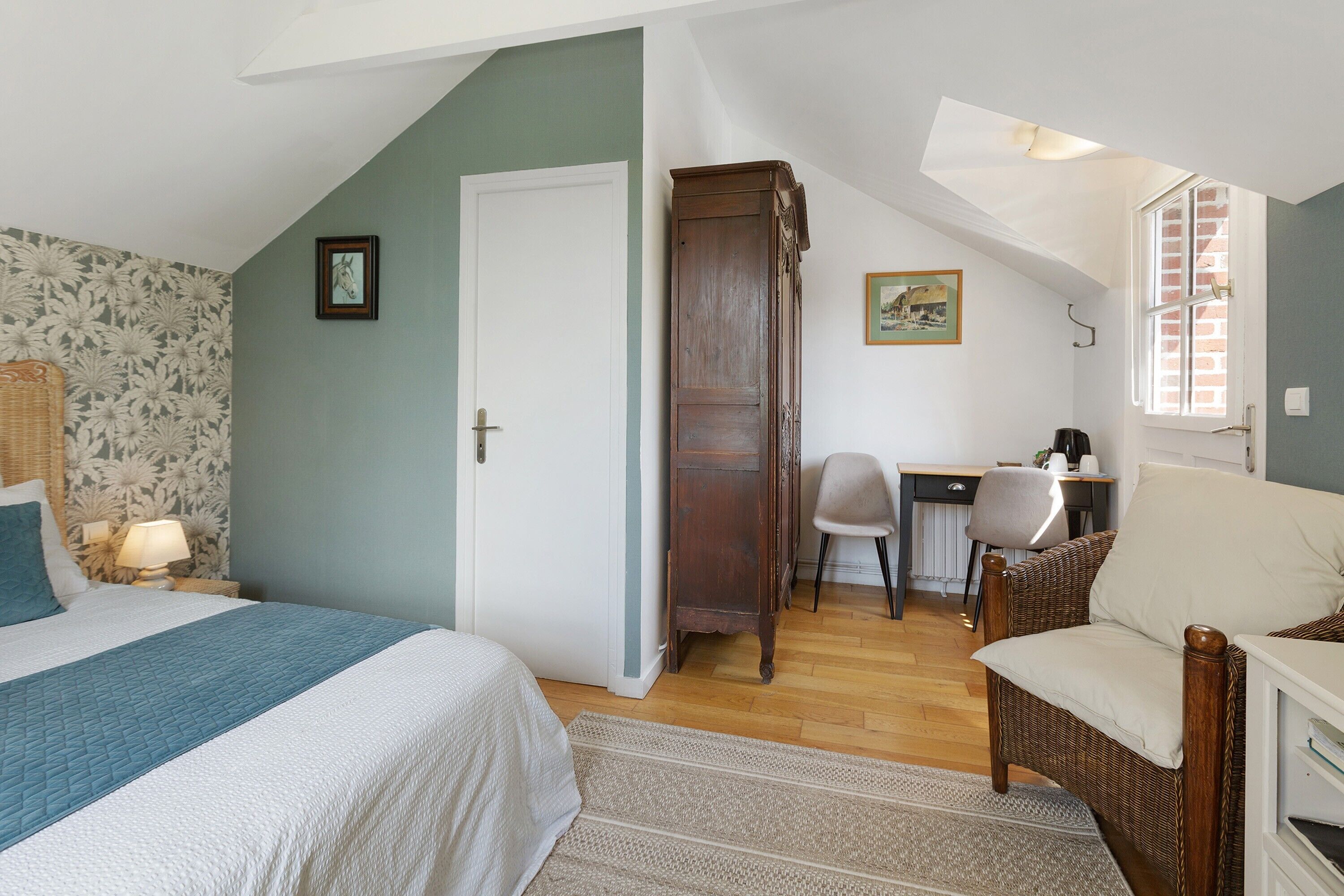 A bedroom with a bed, a desk, a chair, and a window.