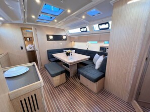 A compact interior with a dining area, seating, and a small kitchenette. - Sun-Kissed Sailing Adventure in Istria, Croatia (Pula)