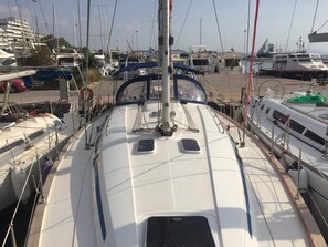 Ein Yachthafen mit mehreren angestaubten Booten, darunter ein weißes Boot mit blauem Streifen und ein Boot mit der Aufschrift 'PILOT'.