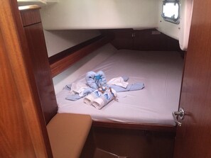 Una cabaña pequeña con una cama individual, un banco y una ventana.
