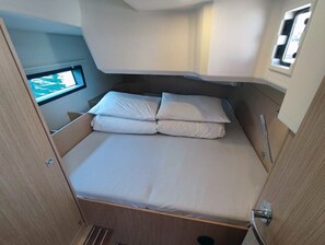 Ein kompakter Wohnmobil mit einem Einzelbett und einem Fenster mit Blick ins Freie.