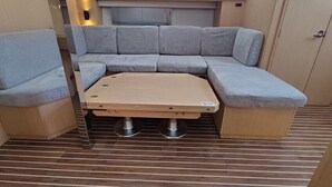 A compact living space with a sofa, a small table, and a window. - Sun-Kissed Sailing Adventure in Northern Croatia (Punat)