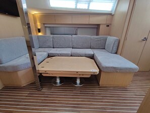 Ein kompakter Wohnraum mit einer Couch, einem kleinen Tisch und einem Fenster.